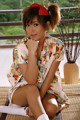 A woman in a kimono sitting on a bamboo mat.