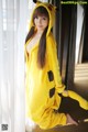 A woman in a yellow pikachu costume posing for a picture.