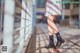 A woman in a plaid skirt and black shoes is walking down the street.