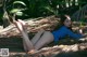 A woman laying on top of a palm tree.