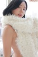 A woman in a white fur vest posing for a picture.