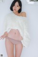 a woman in a white sweater and panties posing for a picture