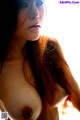 A woman with long red hair is posing naked. 