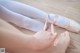 A close up of a person tying up a pair of ballet shoes.