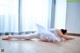 A woman in a white tutu is laying on the floor.