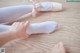 A pair of white ballet shoes with a pink bow on them.