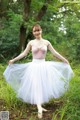 A young ballerina in a pink leotard and a white tutu.