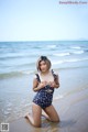 A woman in a bathing suit sitting on the beach.