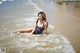 A woman in a bathing suit sitting in the water.