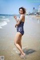 A woman in a bathing suit standing in the water.