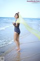 A woman in a bathing suit standing on the beach.