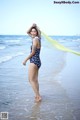 A woman in a bathing suit standing in the ocean.