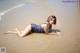 A woman in a bathing suit laying on the beach.