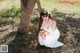 A woman in a white dress sitting under a tree.