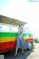 A woman standing in front of a colorful van.