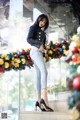 A woman standing in front of a Christmas wreath.