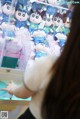 A woman looking at a display case filled with stuffed animals.