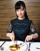 A woman sitting at a table with a plate of food.