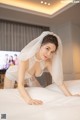 A woman in a wedding dress laying on a bed.