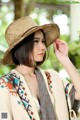 A woman wearing a straw hat is posing for a picture.