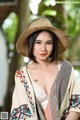 A woman wearing a straw hat and a colorful shawl.