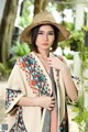 A woman wearing a straw hat and a colorful shawl.