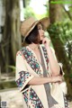 A woman wearing a straw hat is posing for a picture.