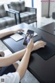 A woman sitting at a table using a cell phone.