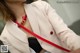 A woman wearing a white blazer and a red belt.