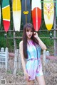 A woman standing in front of a bunch of surfboards.