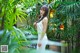 A woman in a white dress standing in a garden.