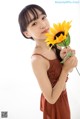 A young girl holding a sunflower in her hand.