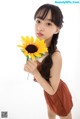 A young girl holding a sunflower in her hand.