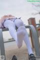 A woman in white tights is sitting on a bench.