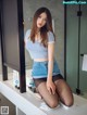 A woman sitting on a counter in a bathroom.