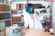 A woman with blue hair is sitting at a desk in front of a typewriter.