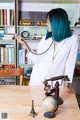 A woman with blue hair sitting at a desk with a stethoscope.