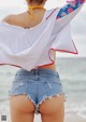 A woman standing on a beach with her back to the camera.