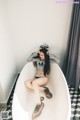 A woman sitting in a bathtub in a bathroom.