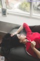 A woman laying on a couch with a pen in her hand.