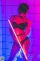 A woman in fishnet stockings holding a light saber.