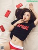 A woman laying on top of a bed next to a cell phone.