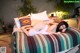 A woman laying on top of a bed covered in pillows.