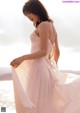 A woman in a white dress standing on the beach.