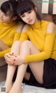 A couple of young women sitting on top of a counter.