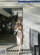 A woman walking down a sidewalk in front of a building.