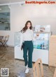 A woman standing in front of a counter holding a drink.