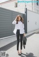 A woman wearing a white and black striped shirt and black pants.