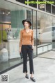 a woman standing in front of a store wearing a hat