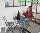 a woman sitting at a table with a cup of coffee